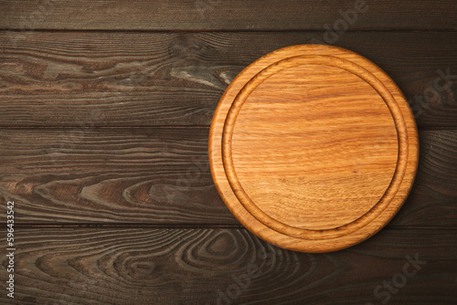 Cutting board on a brown wooden kitchen table. Menu food card or recipes background concept.MOCKUP. Design. Place for text, copy space. The concept of food and cooking.