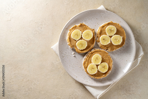 Rice cakes with banana and peanut butter, healthy protein snack, top view, copy space
