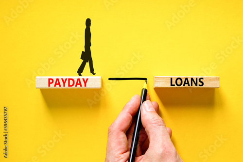 Payday loans symbol. Concept words Payday loans on beautiful wooden block. Beautiful yellow table yellow background. Businessman hand. Businesswoman icon. Business and Payday loans concept. Copy space