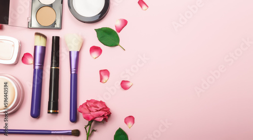Makeup and cosmetic beauty products arranged on a pale pink background. Flat lay. Beauty concept