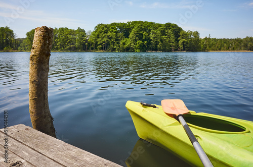 Kayak with a paddle by a lake pier, selective focus. © MaciejBledowski