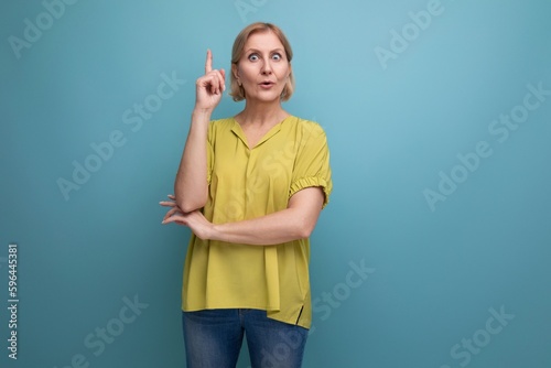thoughtful mature woman demonstrates knowledge on blue background
