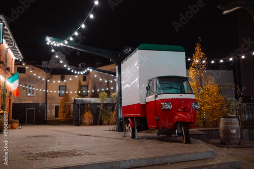 Photography Antique bead car in the color of the Italian flag near the city street cafe at night