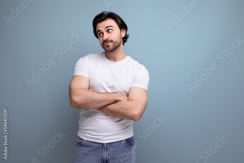 stylish brutal brunette man in a white T-shirt lazily waiting for someone