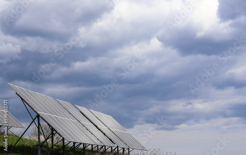 Solar panels on the background of a dark stormy sky. Solar power plant. Solar farm. An alternative source of ecological electricity.