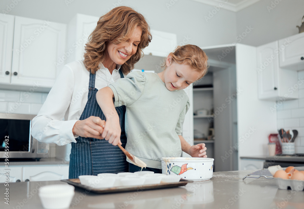 Obraz premium Lets fill them up together. Shot of a grandmother baking with her granddaughter at home.