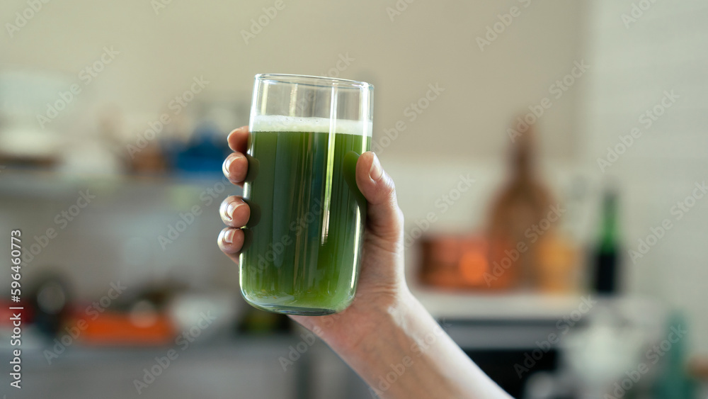 Young woman drinks a glass of green healthy smoothie Young woman drinks a glass of green healthy smoothie