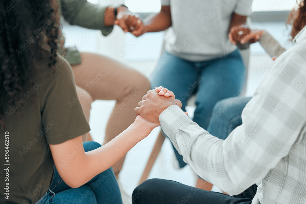 Lets keep each other motivated. Cropped shot of an unrecognisable group of people sitting together and holding hands during prayer. Lets keep each other motivated. Cropped shot of an unrecognisable group of people sitting together and holding hands during prayer.