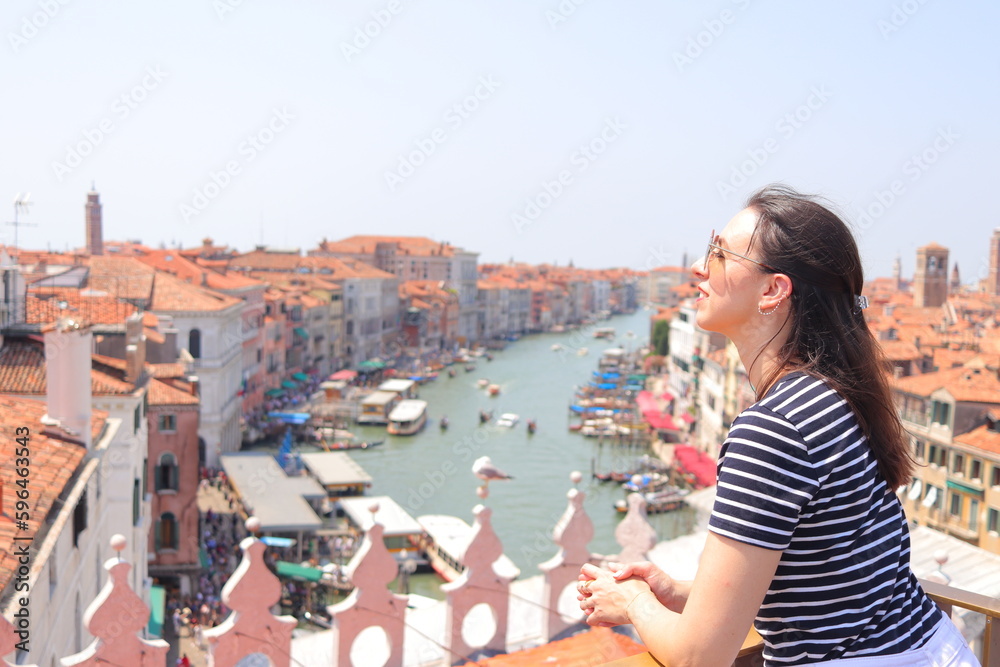 Mujer joven con camiseta de rayas marineras en azotea con vistas al Gran Canal de Venecia