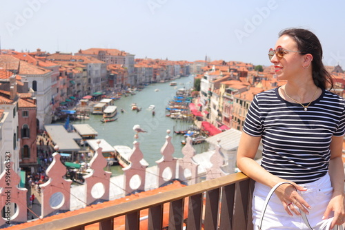 Mujer joven con camiseta de rayas marineras en azotea con vistas al Gran Canal de Venecia photo