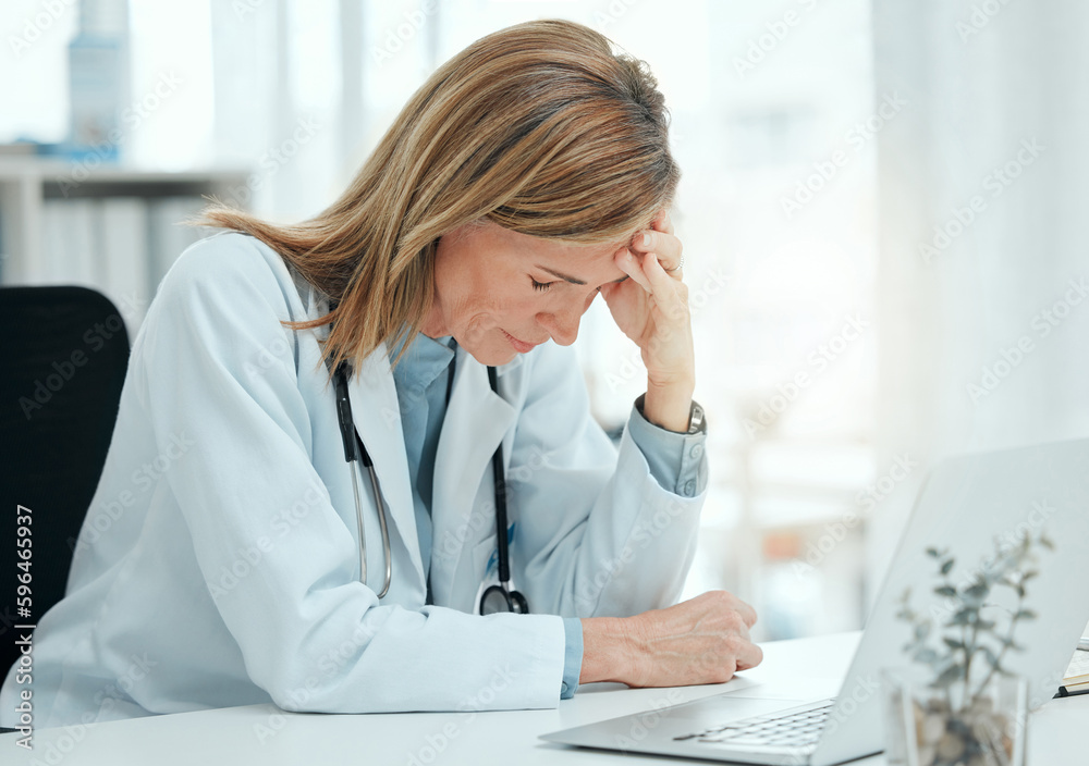 I have such a bad headache. Shot of a mature doctor sitting alone in her clinic and feeling stressed while using her laptop. I have such a bad headache. Shot of a mature doctor sitting alone in her clinic and feeling stressed while using her laptop.