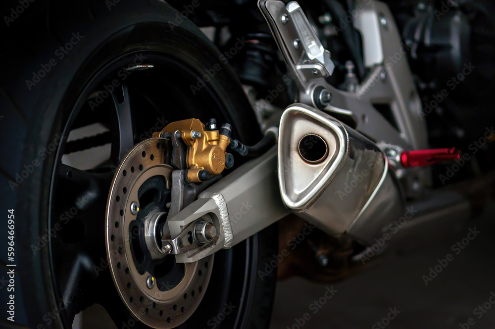 Detail of the exhaust and brake on the wheel of a sports motorcycle.