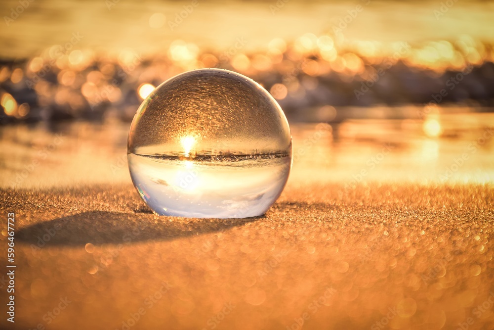 Abstract idea with water with an interesting effect. Glass ball on a blurred background on a seaside beach in Jastarnia, Poland. Photo with a shallow depth of field.