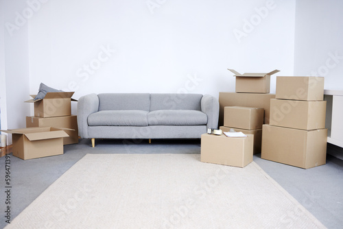 Lets get moving. Shot of cardboard boxes and a sofa in an empty living room during the day. © Azeemud/peopleimages.com