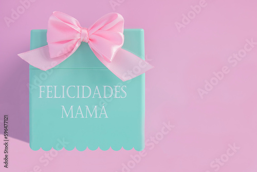 Mother's Day, gift box with pink fabric ribbon and the words in Spanish "felicidades mamá", concept of celebration as a thank you to mothers for their care, joy and affection. © Jordi E.