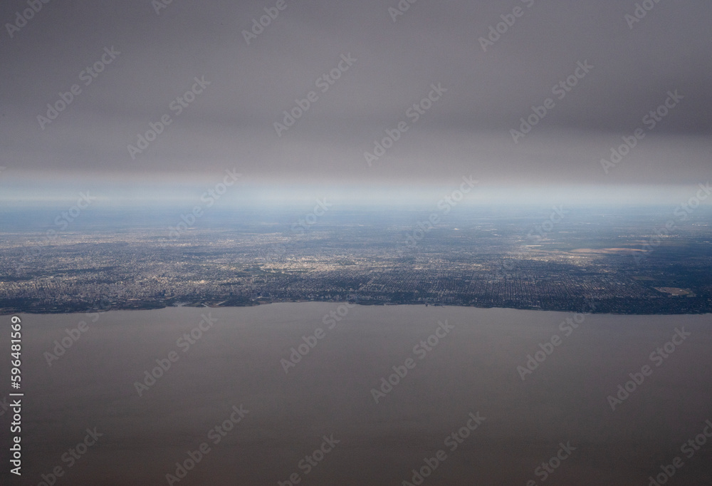 Traveling to Buenos Aires. View of the Rio de la Plata, coastline and city seen from very high in the sky. 