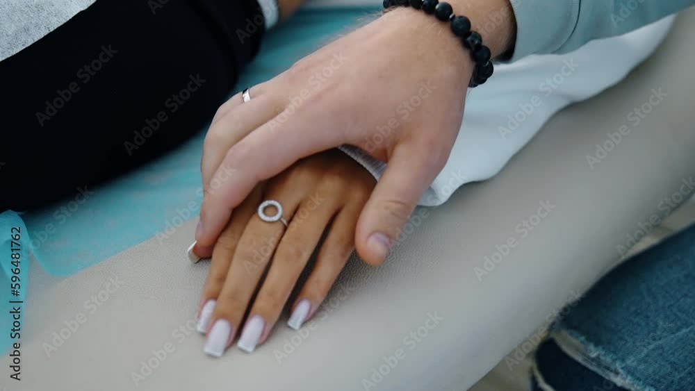 Beautiful female hand lies on the hospital couch. Male hand takes the female ones showing support. Close up. Beautiful female hand lies on the hospital couch. Male hand takes the female ones showing support. Close up.