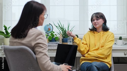Female college student talking to mentor, psychologist in office