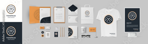 Brand image trademark with mountain in circle logo on orange background. Vector set of templates include folder, business card, envelope, A4 form, t-shirt, street lightbox, notepad, paperbag and book. photo