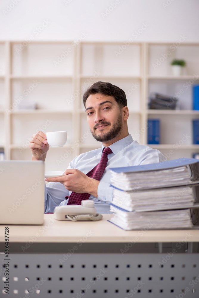 Young male employee drinking coffee during break Young male employee drinking coffee during break