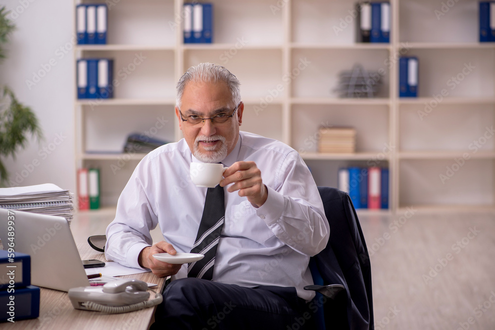 Old male employee working in the office Old male employee working in the office
