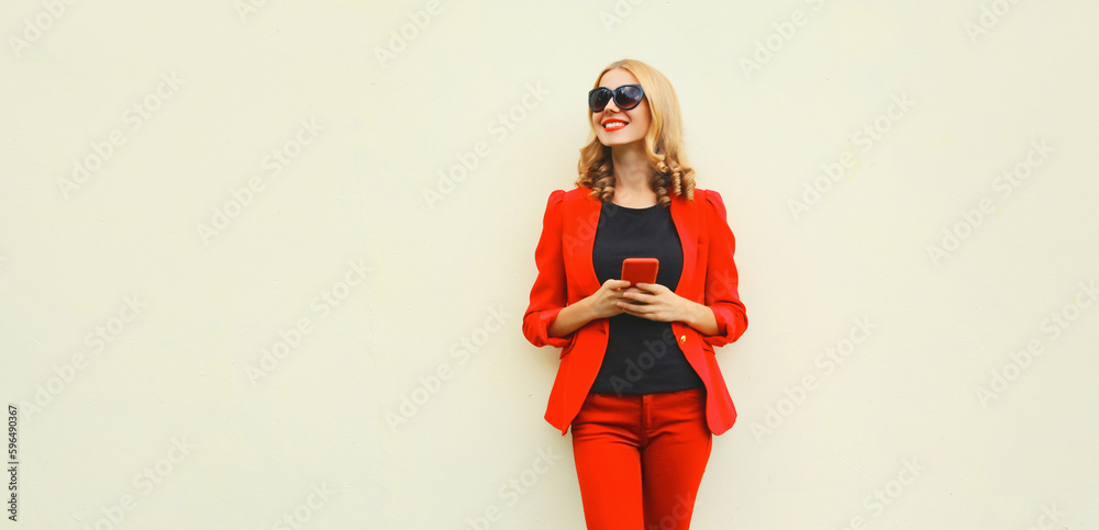 Portrait of beautiful smiling elegant lady woman with smartphone wearing red business blazer on white background Portrait of beautiful smiling elegant lady woman with smartphone wearing red business blazer on white background