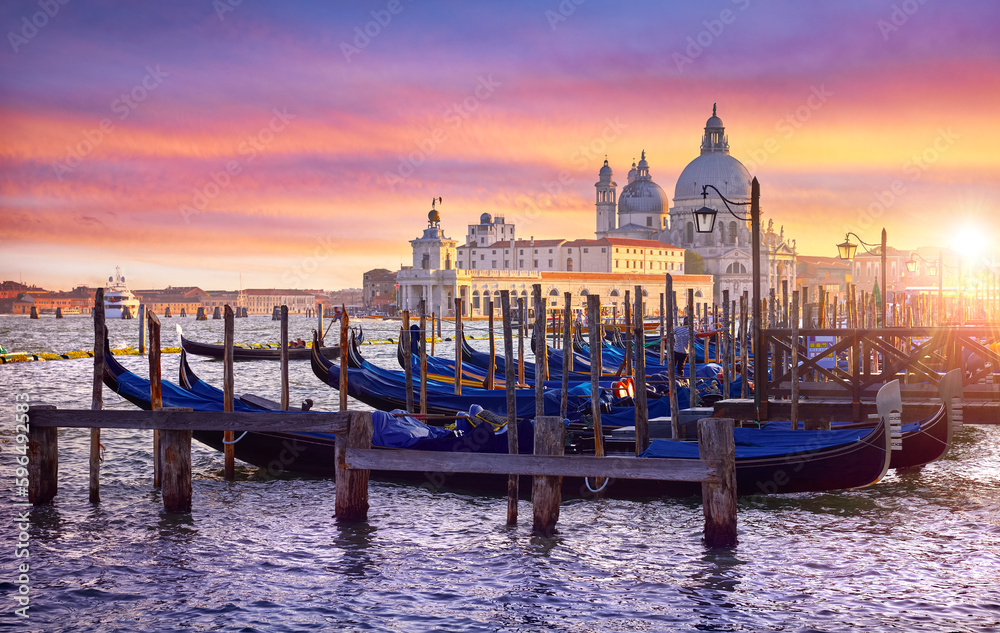 Venice Italy. Gondolas floqting by the docks of Grand Canal in Venezia. Sunset view Cathedral Santa Maria della Salute Picturesque panoramic skyline landscape