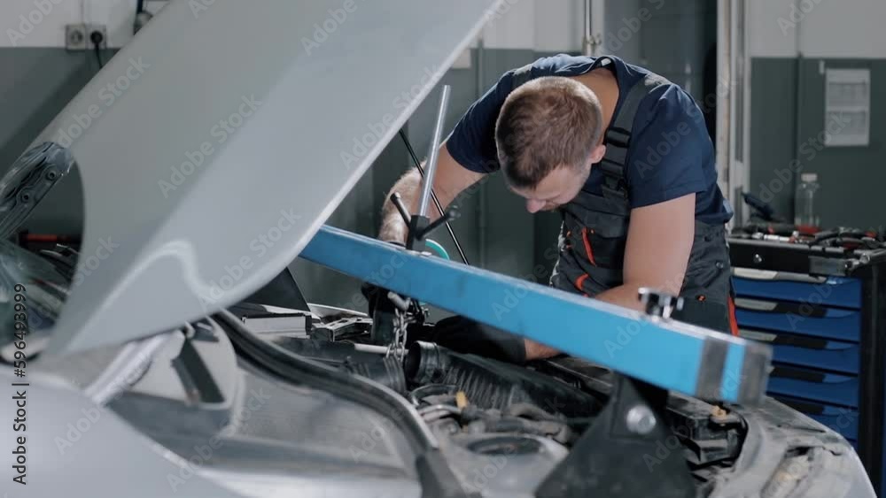 an auto mechanic fixes a gearbox with a safety device, for repairs in a modern car. professional car service. Replacement of warranty parts. an auto mechanic fixes a gearbox with a safety device, for repairs in a modern car. professional car service. Replacement of warranty parts.