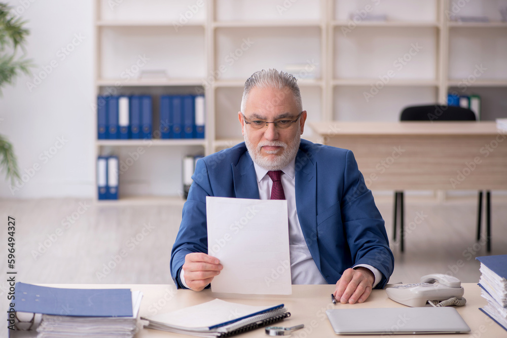 Old male employee and too much work at workplace Old male employee and too much work at workplace