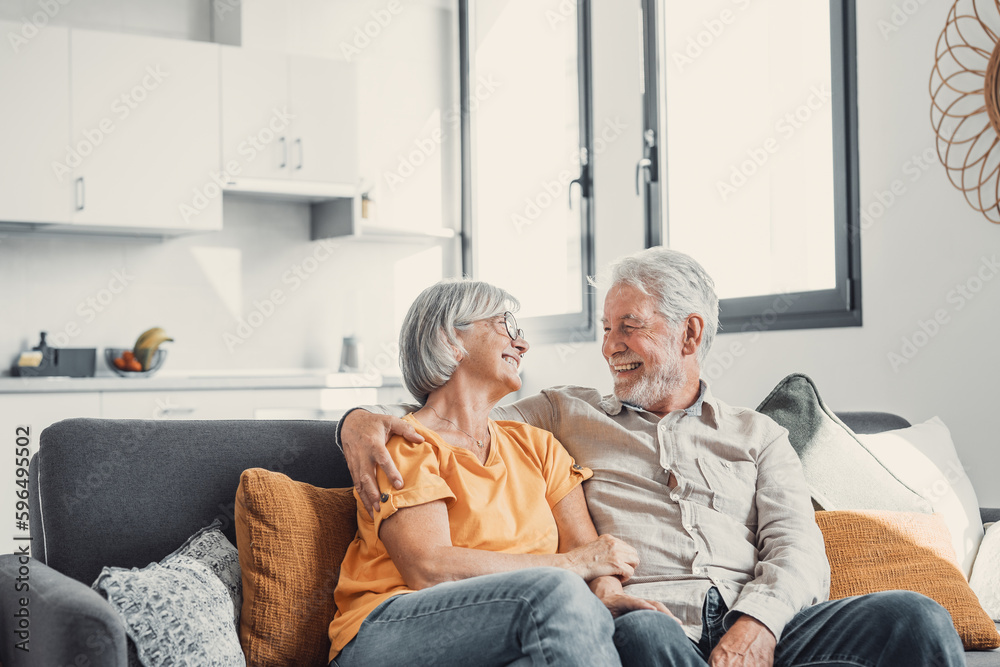 Happy laughing older married couple talking, laughing, standing in home interior together, hugging with love, enjoying close relationships, trust, support, care, feeling joy, tenderness. - obrazy, fototapety, plakaty 
