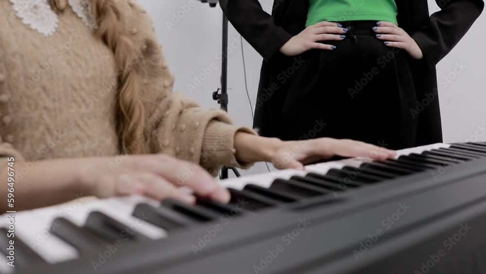Close-up of a teacher's hands playing a synthesizer giving a lesson on vocals. Singing lesson.