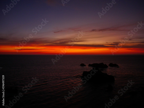 Seaside Sunset with Rock Formation Silhouette and Colorful Sky Horizon View