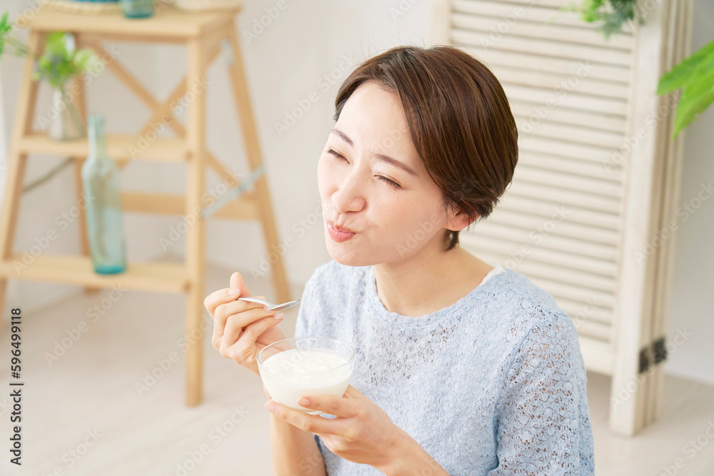 自宅でヨーグルトを食べる女性 自宅でヨーグルトを食べる女性