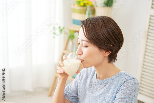 自宅で豆乳を飲む女性