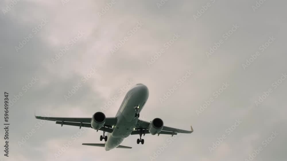 Arriving large passenger airplane, aircraft, airliner is flying in the overcast, gray sky. Arrival, incoming, approaching, journey, flight and tourism concept Arriving large passenger airplane, aircraft, airliner is flying in the overcast, gray sky. Arrival, incoming, approaching, journey, flight and tourism concept