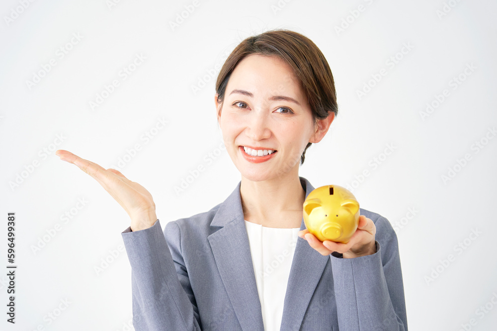 貯金箱を持って手のひらで左を指すビジネスウーマン 白背景 貯金箱を持って手のひらで左を指すビジネスウーマン 白背景