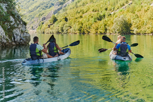 A group of friends enjoying having fun and kayaking while exploring the calm river, surrounding forest and large natural river canyons © .shock