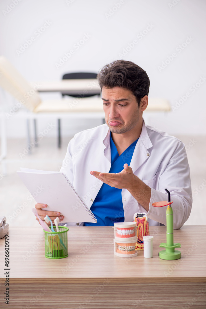 Young male dentist working in the clinic Young male dentist working in the clinic