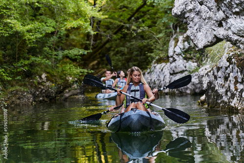 A group of friends enjoying having fun and kayaking while exploring the calm river, surrounding forest and large natural river canyons © .shock