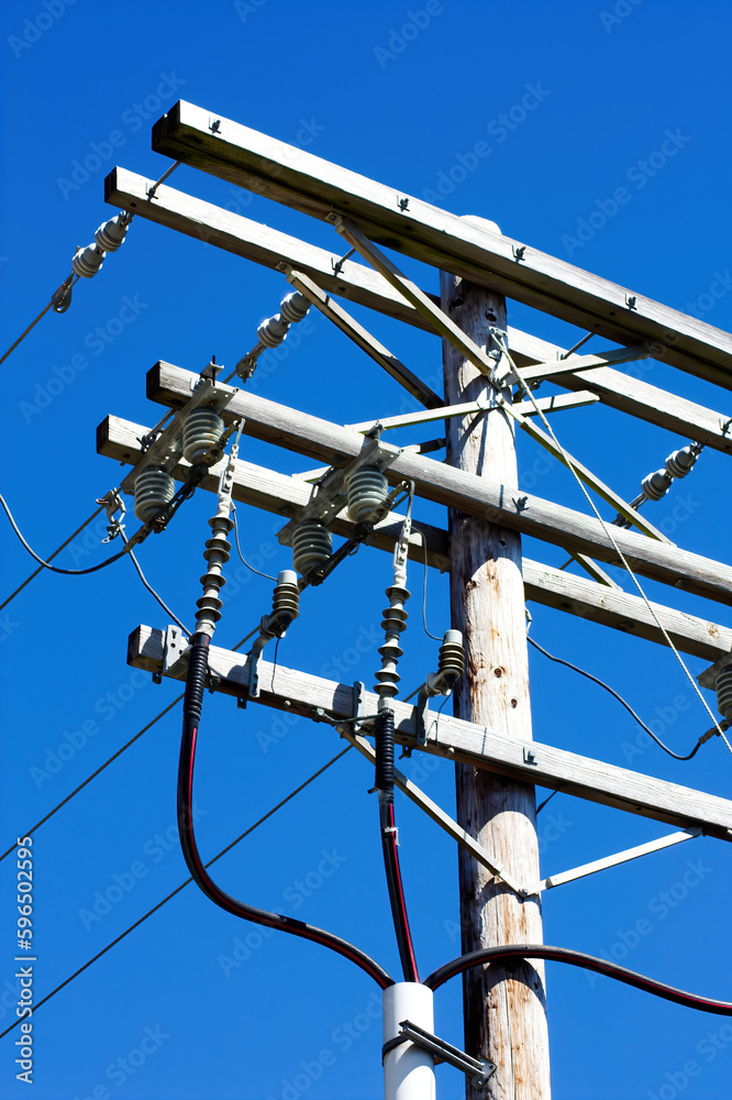 Tight Shot Of Wooden Power Pole Against Blue Sky Tight Shot Of Wooden Power Pole Against Blue Sky