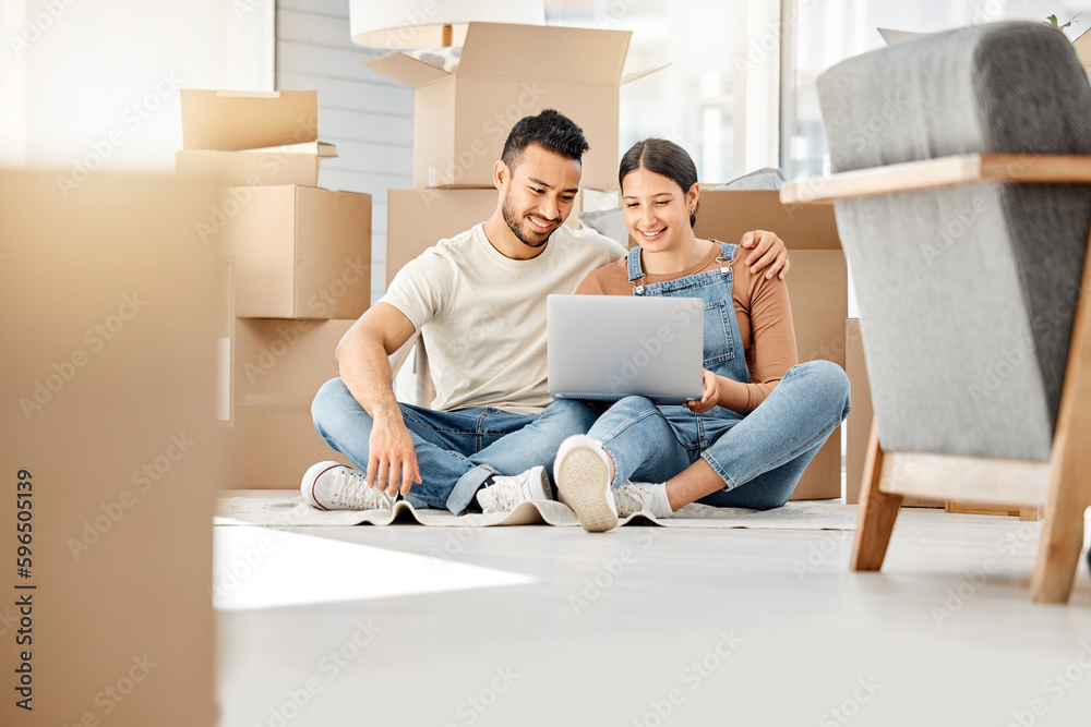 Lets see what furniture we can buy online. Shot of a young couple using a laptop while moving house.