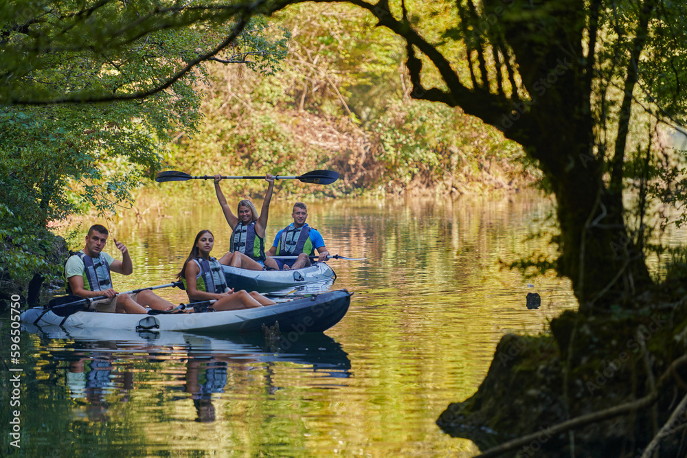 A group of friends enjoying having fun and kayaking while exploring the calm river, surrounding forest and large natural river canyons A group of friends enjoying having fun and kayaking while exploring the calm river, surrounding forest and large natural river canyons