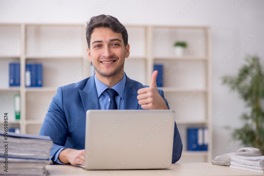 Young male employee working in the office Young male employee working in the office