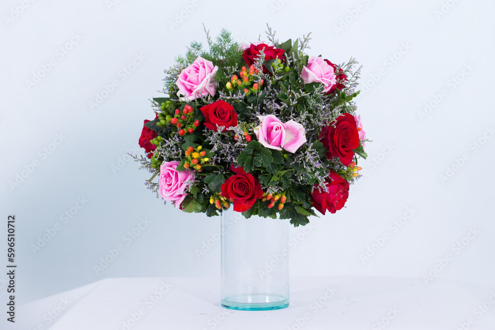 Many kinds of flowers placed in a brightly colored vase in a white setting Many kinds of flowers placed in a brightly colored vase in a white setting