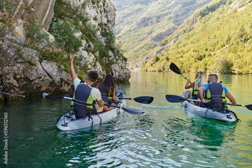 A group of friends enjoying having fun and kayaking while exploring the calm river  surrounding forest and large natural river canyons