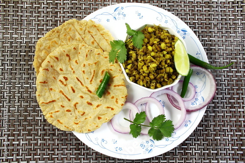 traditional indian gujarati food dish sprouted mung beans masala curry stew recipe with roti or bhakhri or chapati photo