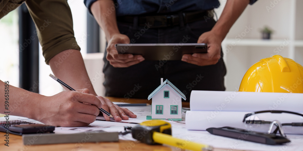 Architect and Engineer working with blueprints for architectural plan, engineer sketching a construction project, green energy concept Architect and Engineer working with blueprints for architectural plan, engineer sketching a construction project, green energy concept