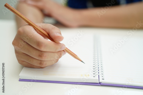 Asian teenage student write homework  study lesson for exam online learning education.