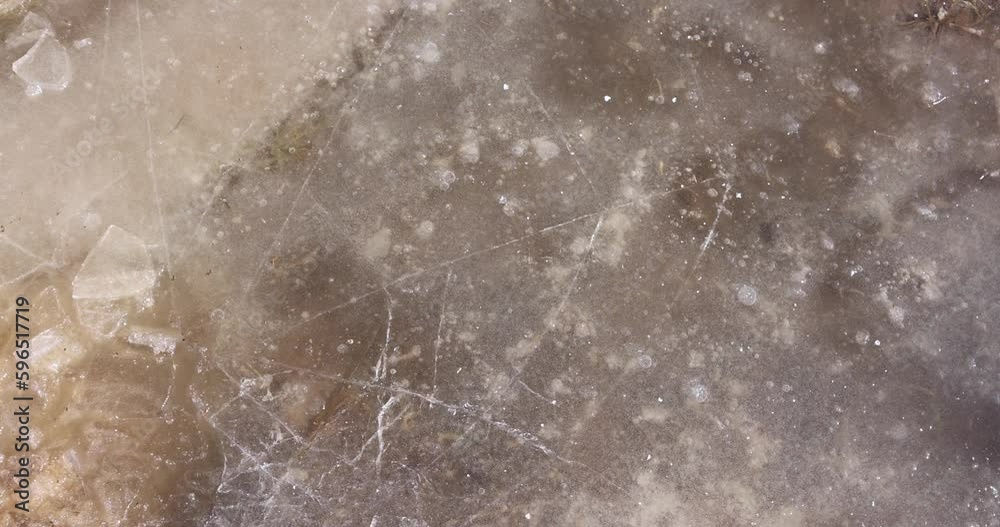 frozen puddles in an agricultural field with fertile soil, frozen dirty water in puddles on the soil frozen puddles in an agricultural field with fertile soil, frozen dirty water in puddles on the soil