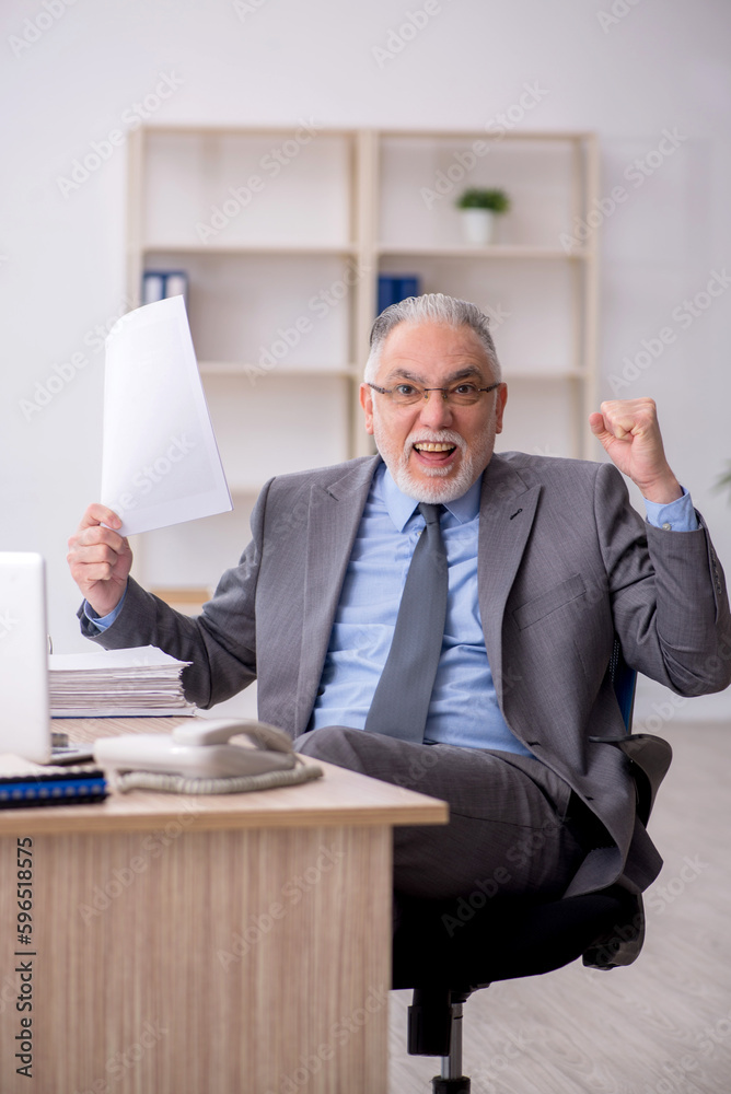 Old male employee working in the office Old male employee working in the office